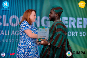 USAID Michael Ackon accepts his award from Michelle Barrett, Deputy Mission Director, USAID West Africa