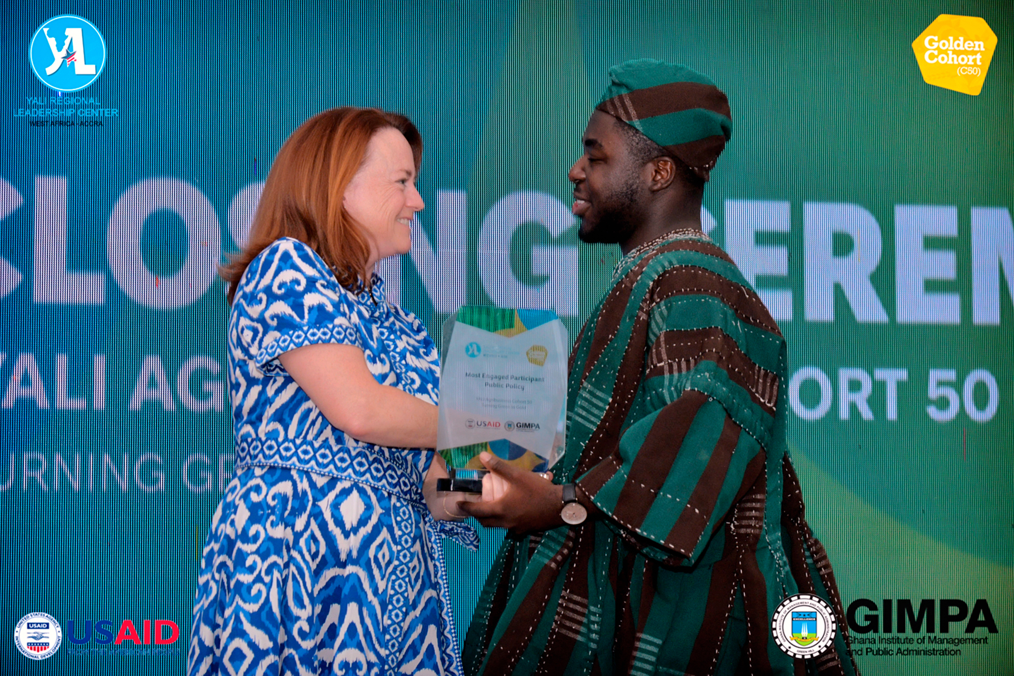 USAID Michael Ackon accepts his award from Michelle Barrett, Deputy Mission Director, USAID West Africa